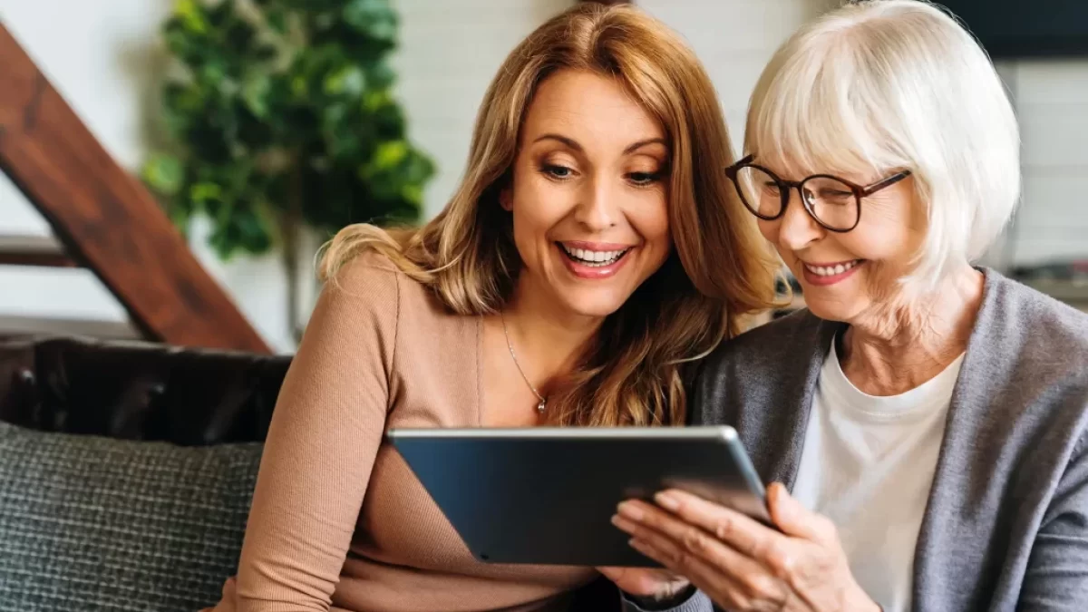 seniorka s dcerou čtou zprávu z tabletu