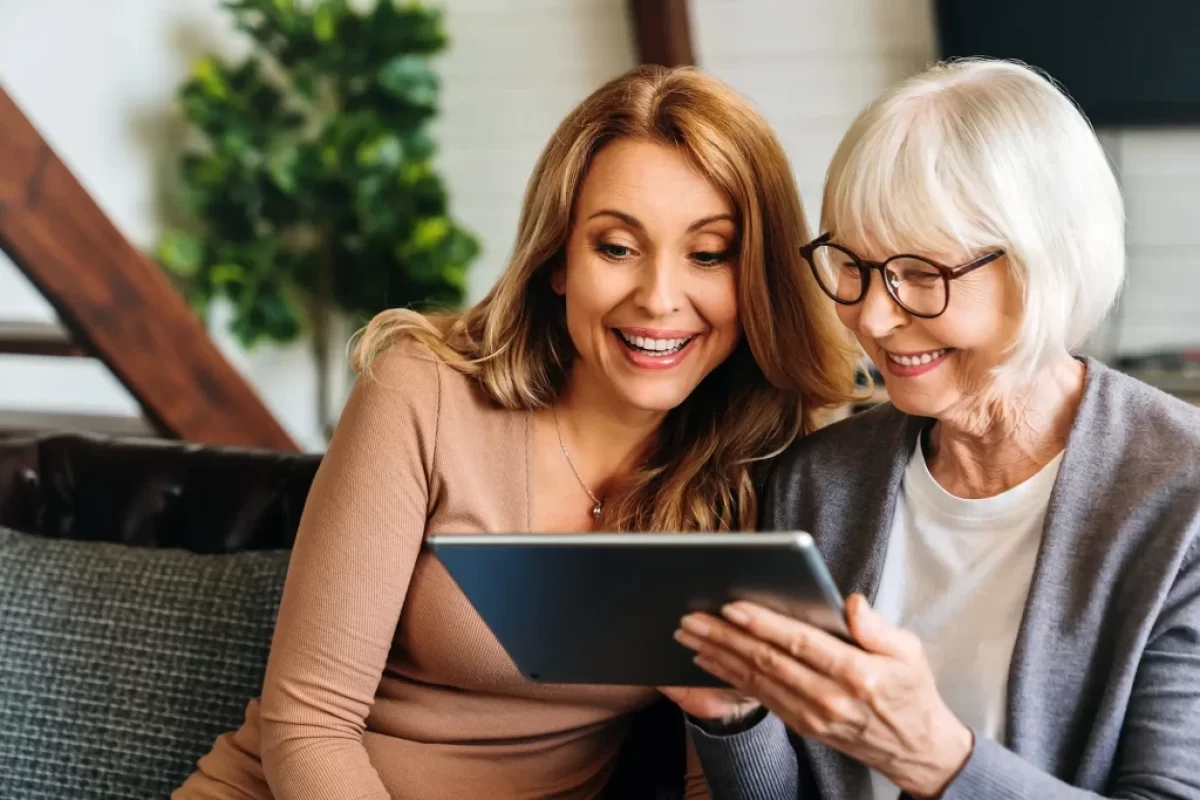 seniorka s dcerou čtou zprávu z tabletu