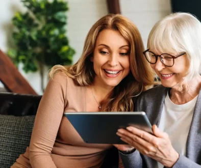 seniorka s dcerou čtou zprávu z tabletu
