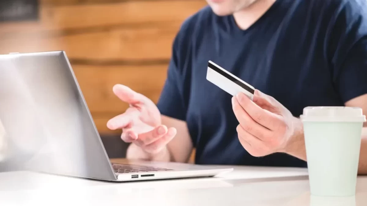 Muž je zmatený s kartou u laptopu
