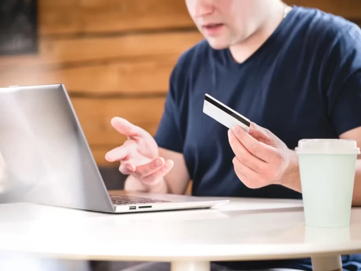 Muž je zmatený s kartou u laptopu