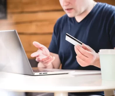 Muž je zmatený s kartou u laptopu