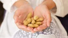 žena drží arašídy v ruce
