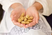 žena drží arašídy v ruce