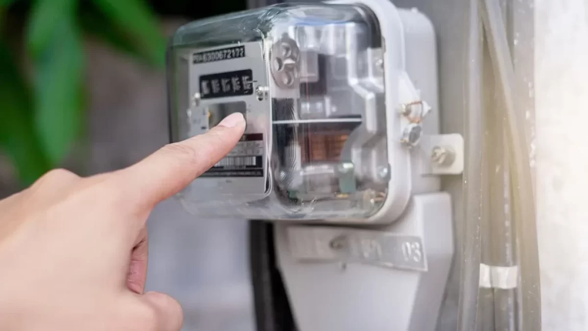 Ruka ukazuje na elektroměřák