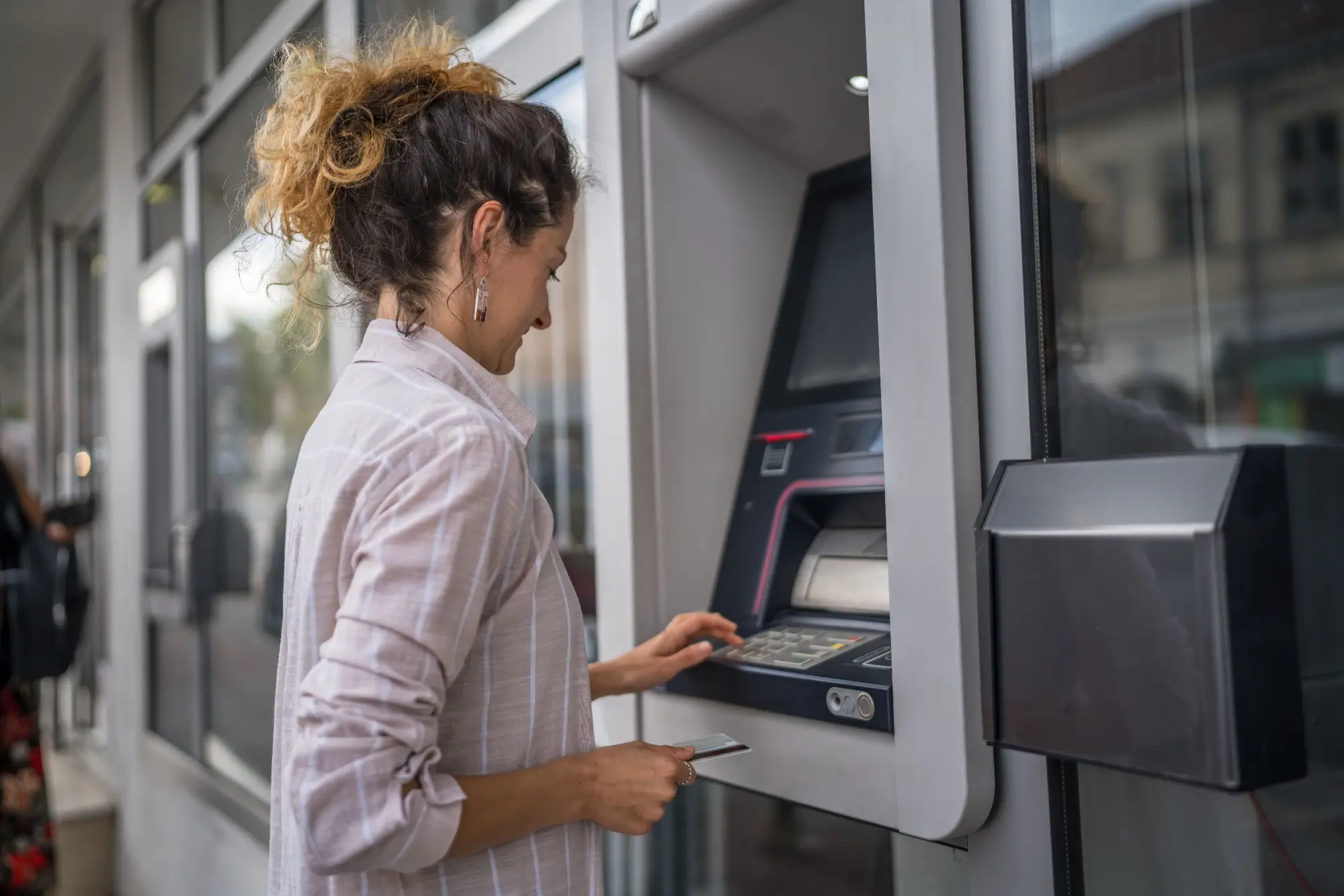 Shutterstock_2346423029 - Techsvět Žena vybírá peníze z bankomatu