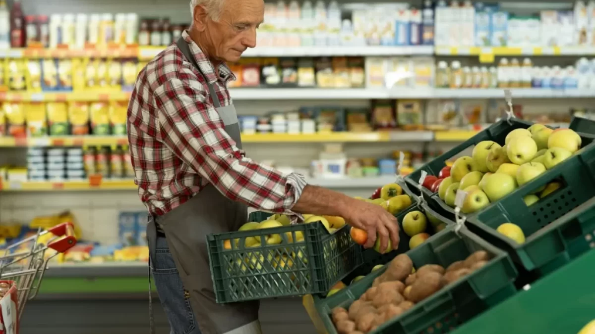 Pracovník supermarketu přerovnává ovoce