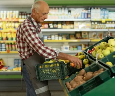 Pracovník supermarketu přerovnává ovoce