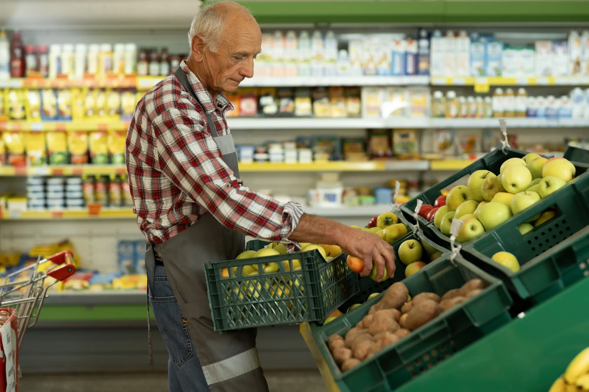 Pracovník supermarketu přerovnává ovoce
