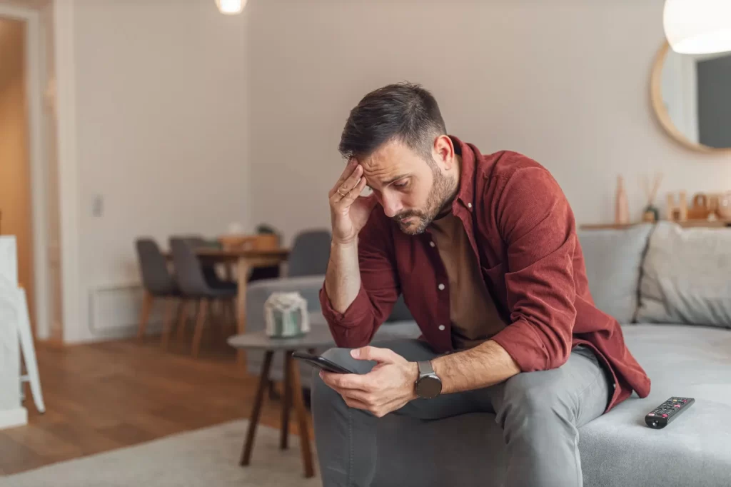 smutný muž na telefonu