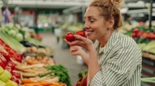 Žena v obchodě nakupuje rajčata