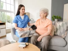 Doktorka měří tlak seniorce doma