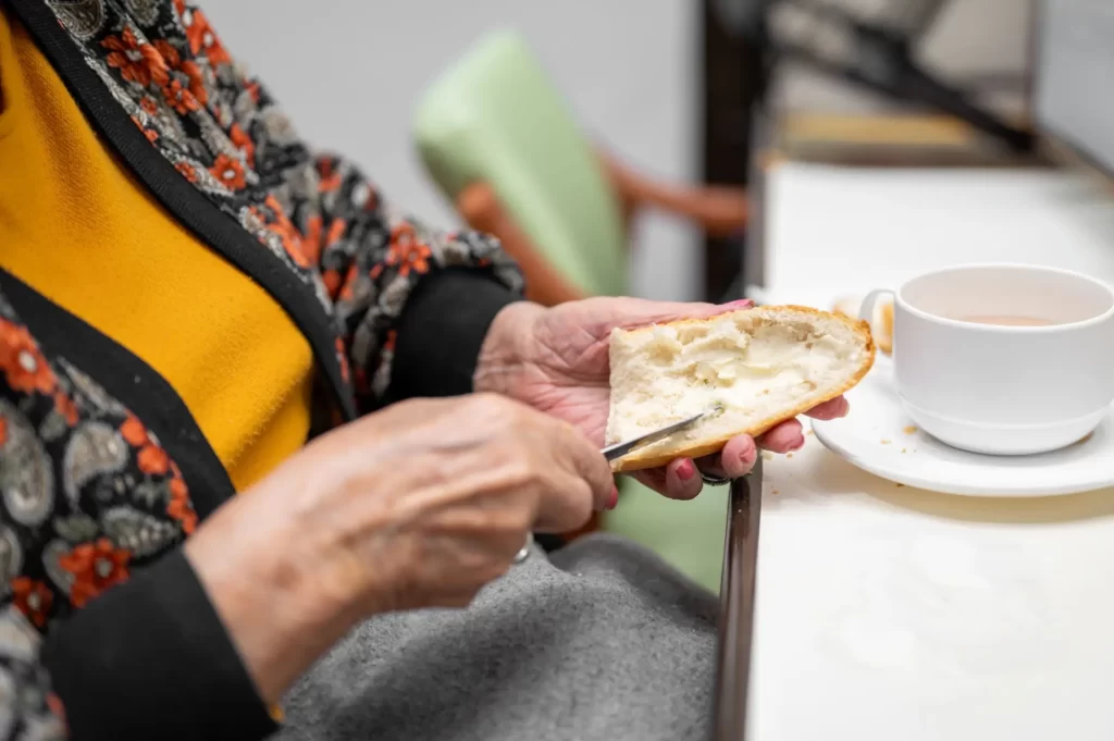 Shutterstock_2482302741 - Techsvět Seniorka si maže pečivo máslem