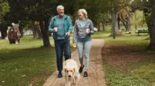 Pár v důchodovém věku na procházce se psem