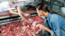 žena vybírá maso z pultu