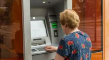 Seniorka vybírá z bankomatu