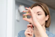 žena zkoumá lupou minci