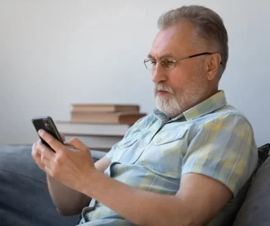 Senior se dívá do mobilu