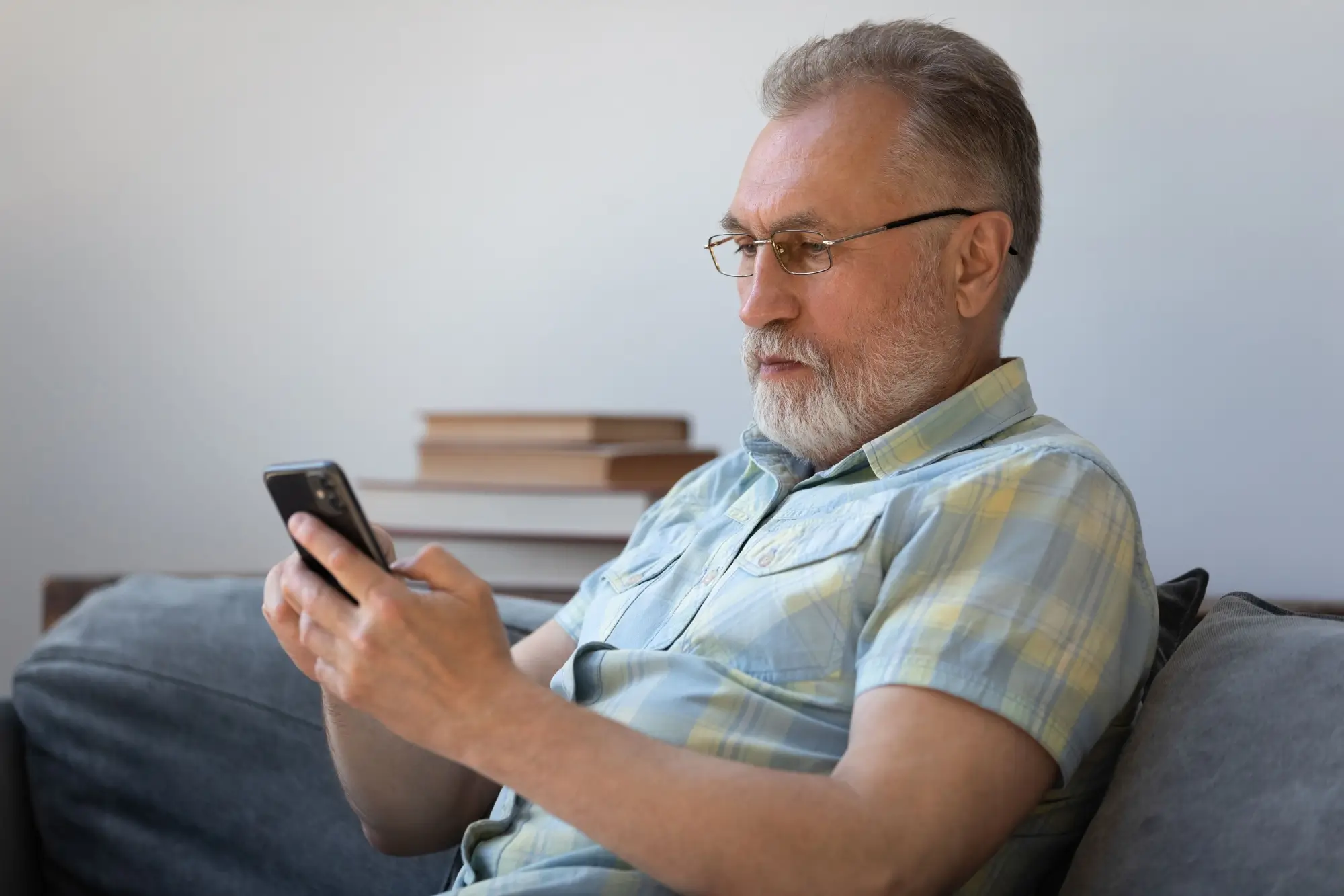 Senior se dívá do mobilu