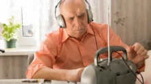 Senior se sluchátky poslouchá rádio