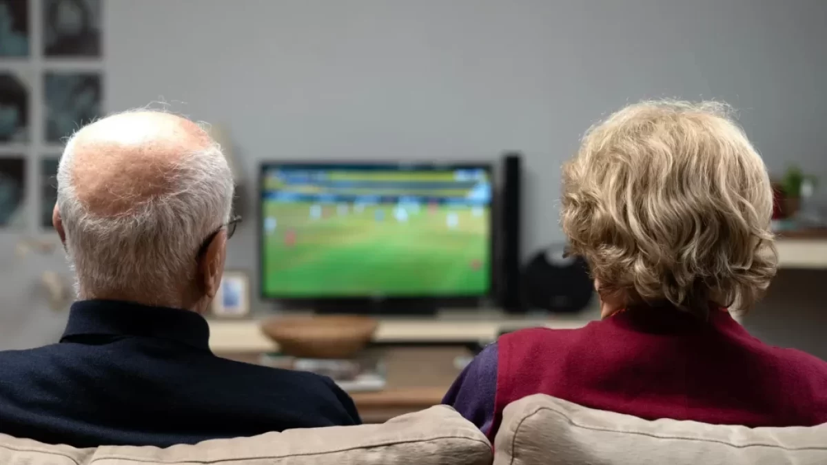 Husák s manželkou sledují televizi