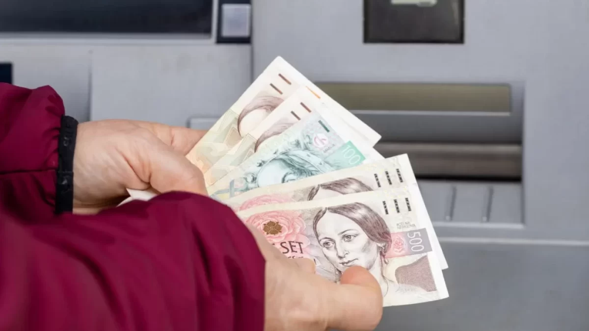 Muž vybírá peníze z bankomatu