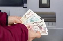 Muž vybírá peníze z bankomatu