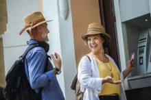 Žena a muž vybírající peníze z bankomatu.