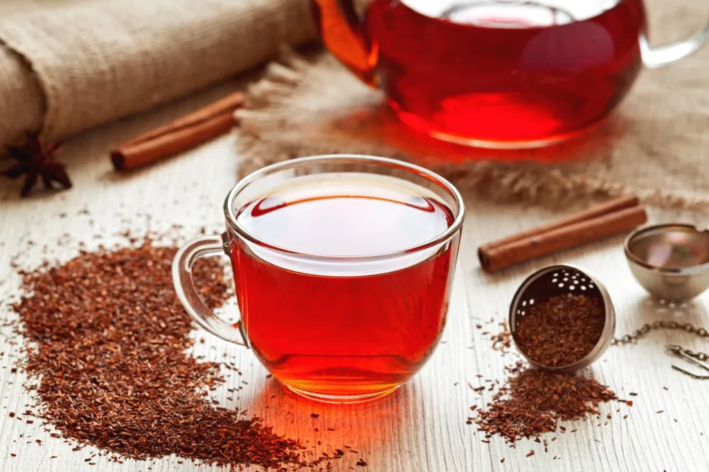 čaj2 - Techsvět Skleněný šálek plný rooibos čaje s jeho typickou červenohnědou barvou.
