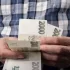Muž v kostkované košili počítá peníze