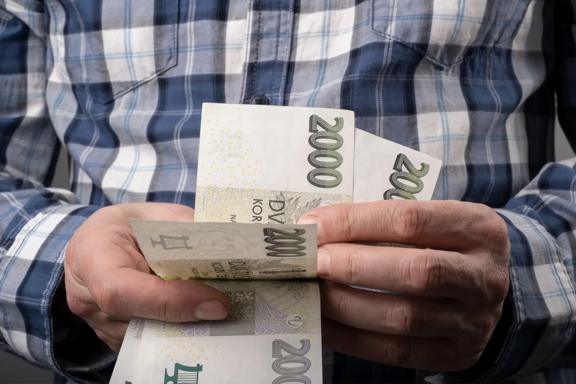 Muž v kostkované košili počítá peníze
