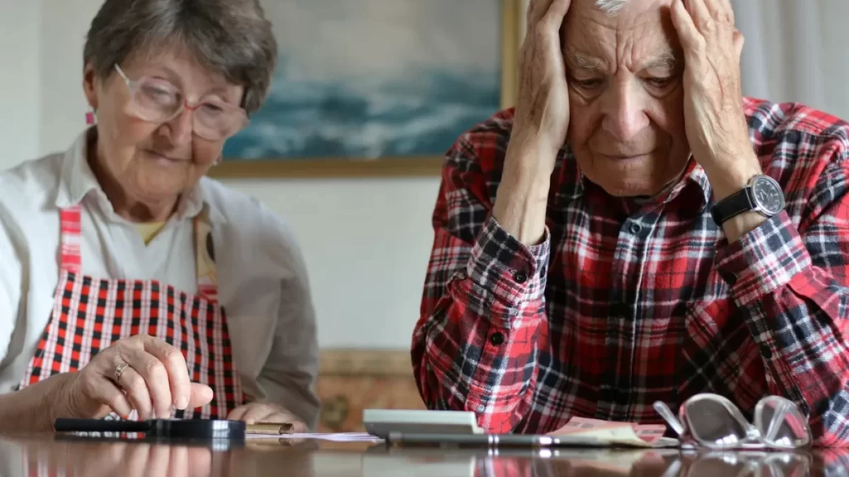 Pár seniorů frustrovaně počítá peníze