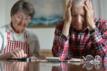 Pár seniorů frustrovaně počítá peníze