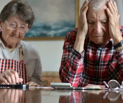 Pár seniorů frustrovaně počítá peníze