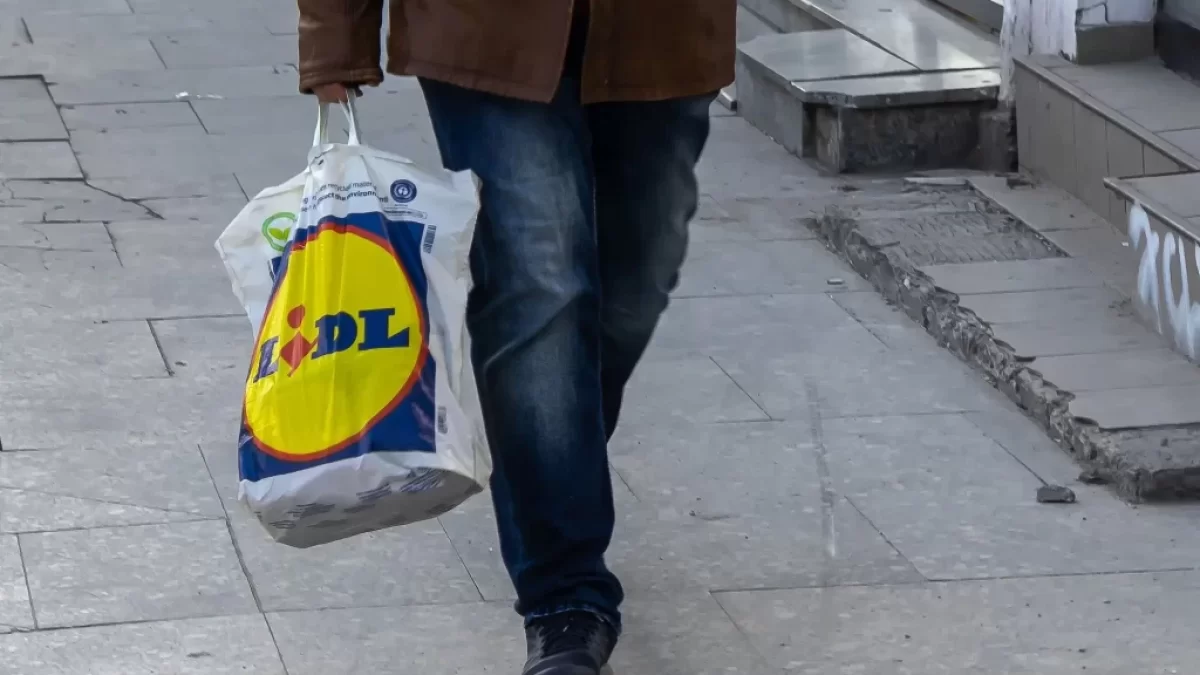 muž nese tašku Lidl