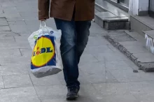muž nese tašku Lidl