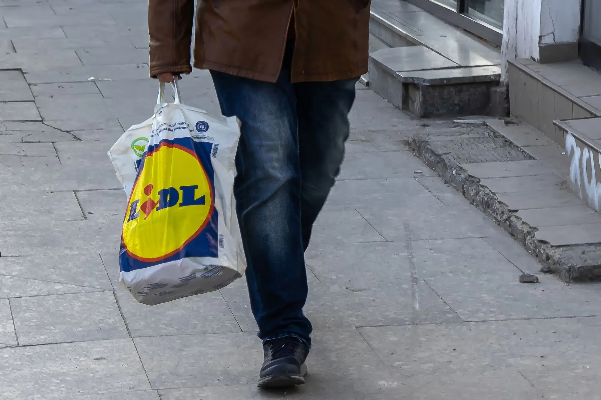 muž nese tašku Lidl