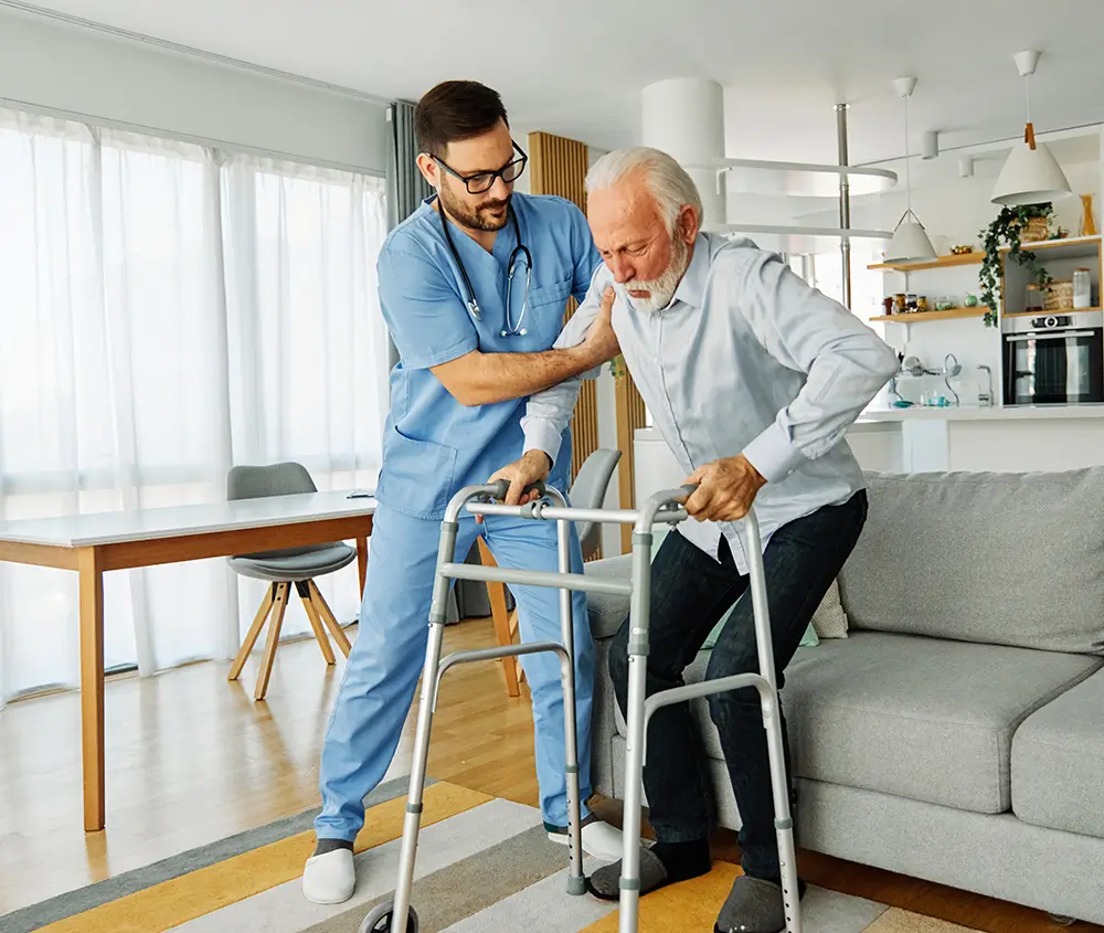 Příspěvek na péči je finanční podpora pro osoby, které se neobejdou bez pomoci jiné osoby při běžných činnostech. - Techsvět pečovatel pomáhá seniorovi s chůzí