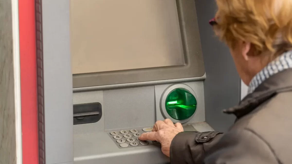 seniorka vybírá peníze z bankomatu