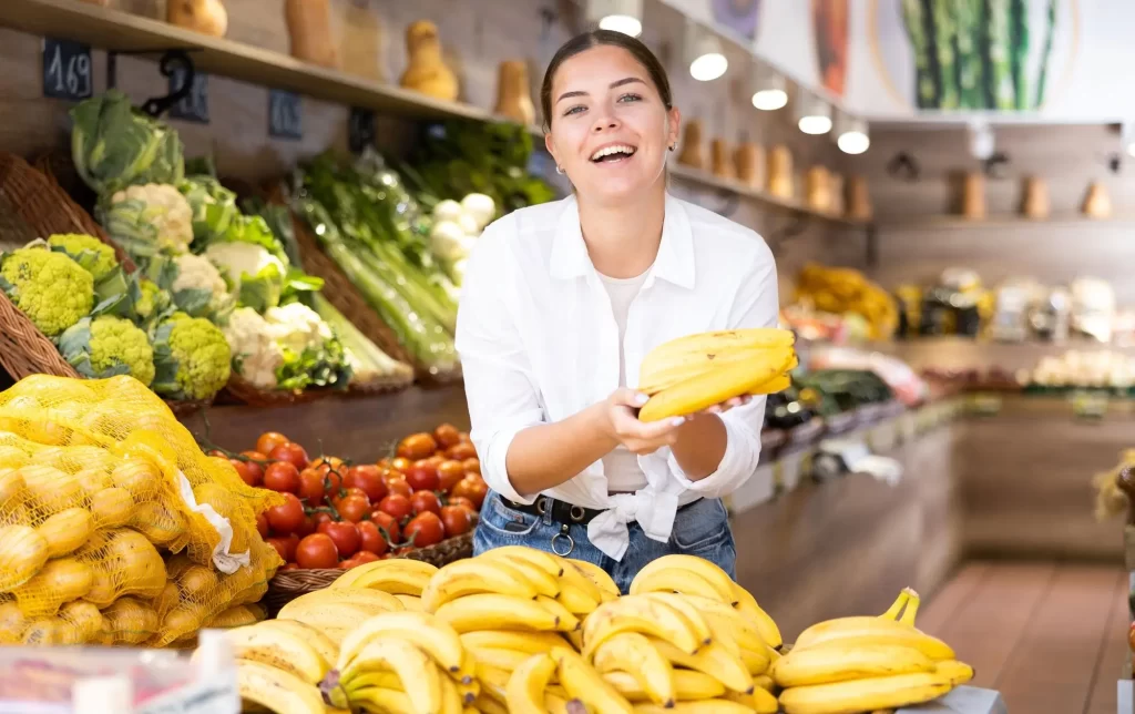 shutterstock_2303516451 - Techsvět usměvavá mladá žena v supermarketu nakupuje banány