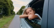 holka kouká z otevřeného okna v autě