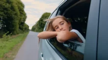 holka kouká z otevřeného okna v autě
