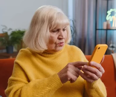 starší žena zmateně zírá na mobil