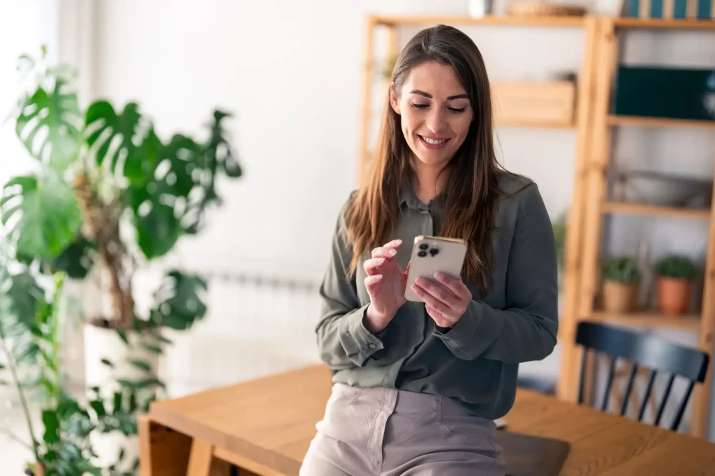 shutterstock_2469702263 - Techsvět usměvavá žena se dívá do mobilu