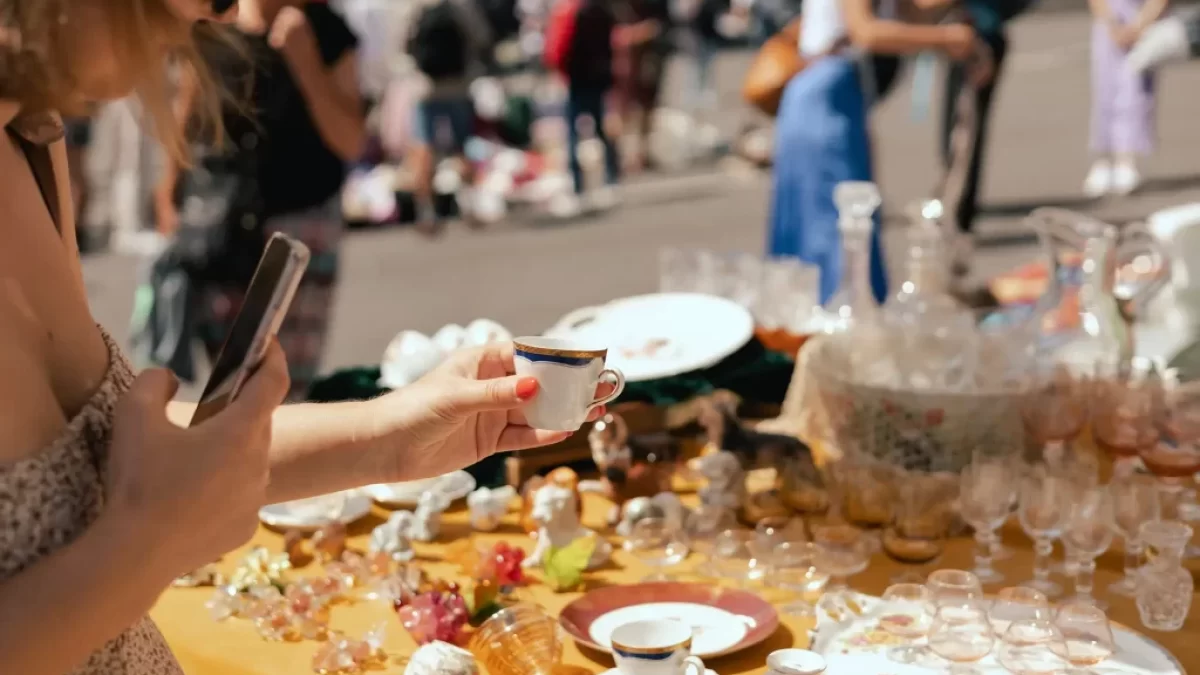 žena vybírá na blešímtrhu porcelán