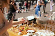 žena vybírá na blešímtrhu porcelán