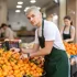 mladý prodavač v supermarketu doplňuje mandarinky