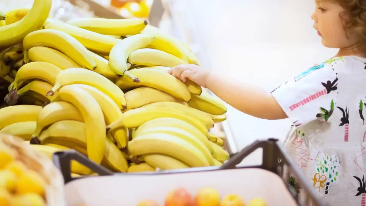 malá dívka si vybírá v supermarketu banány