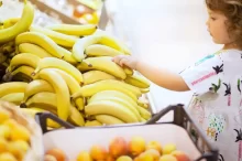 malá dívka si vybírá v supermarketu banány
