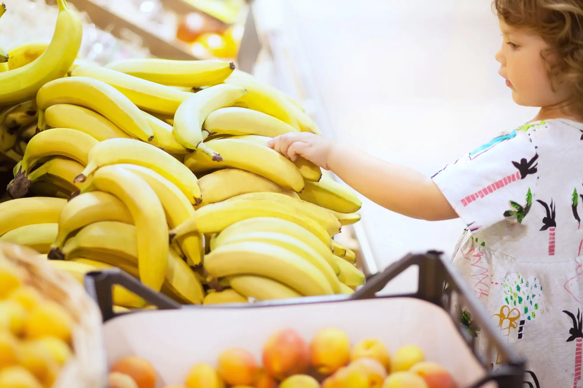 malá dívka si vybírá v supermarketu banány